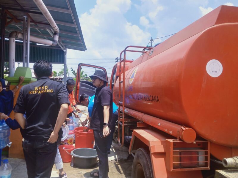 Personel BPBD tengah menyalurkan air bersih pada warga.