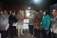 Bupati didampingi Kepala Dinsos menyerahkan bantuan pada warga yang menjadi korban kebakaran di Desa Kota Agung, Bermani Ilir