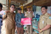 Kepala Dinsos Helmi Johan mendampingi Wabup menyerahkan bantuan tanggap bencana pada korban longsor 