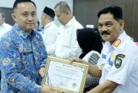 Kepala Dinsos menerima piagam penghargaan oleh Kepala Ombudsman. (foto: Agung Mandala/warta aspirasi)