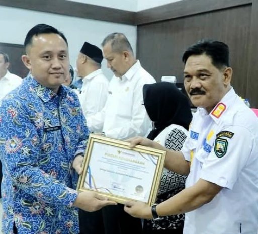 Kepala Dinsos menerima piagam penghargaan oleh Kepala Ombudsman. (foto: Agung Mandala/warta aspirasi)