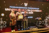 Bupati menerima UHC Awards Kategori Pratama berkat sinergi yang solid dan konsisten antara Pemkab Kepahiang, BPJS Kesehatan, fasilitas kesehatan, serta seluruh pemangku kepentingan terkait. (foto: Kominfotik Kepahiang)